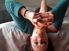 Kleine zelfgemaakte video van volwassen vrouw die kokhalst op dildo ondersteboven