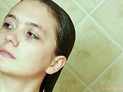 Çekici esmer model sıcak duşta banyo yapıyor